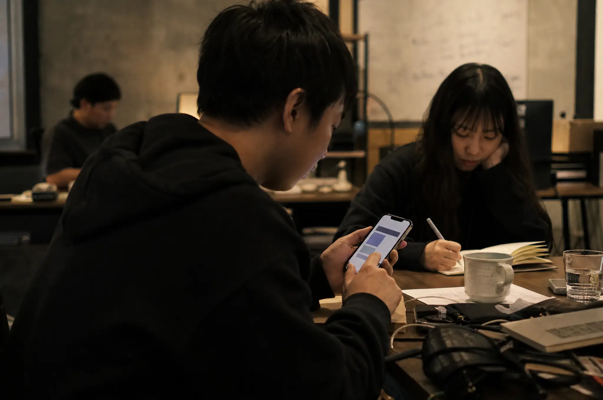 Participant testing a mobile prototype while a researcher takes notes