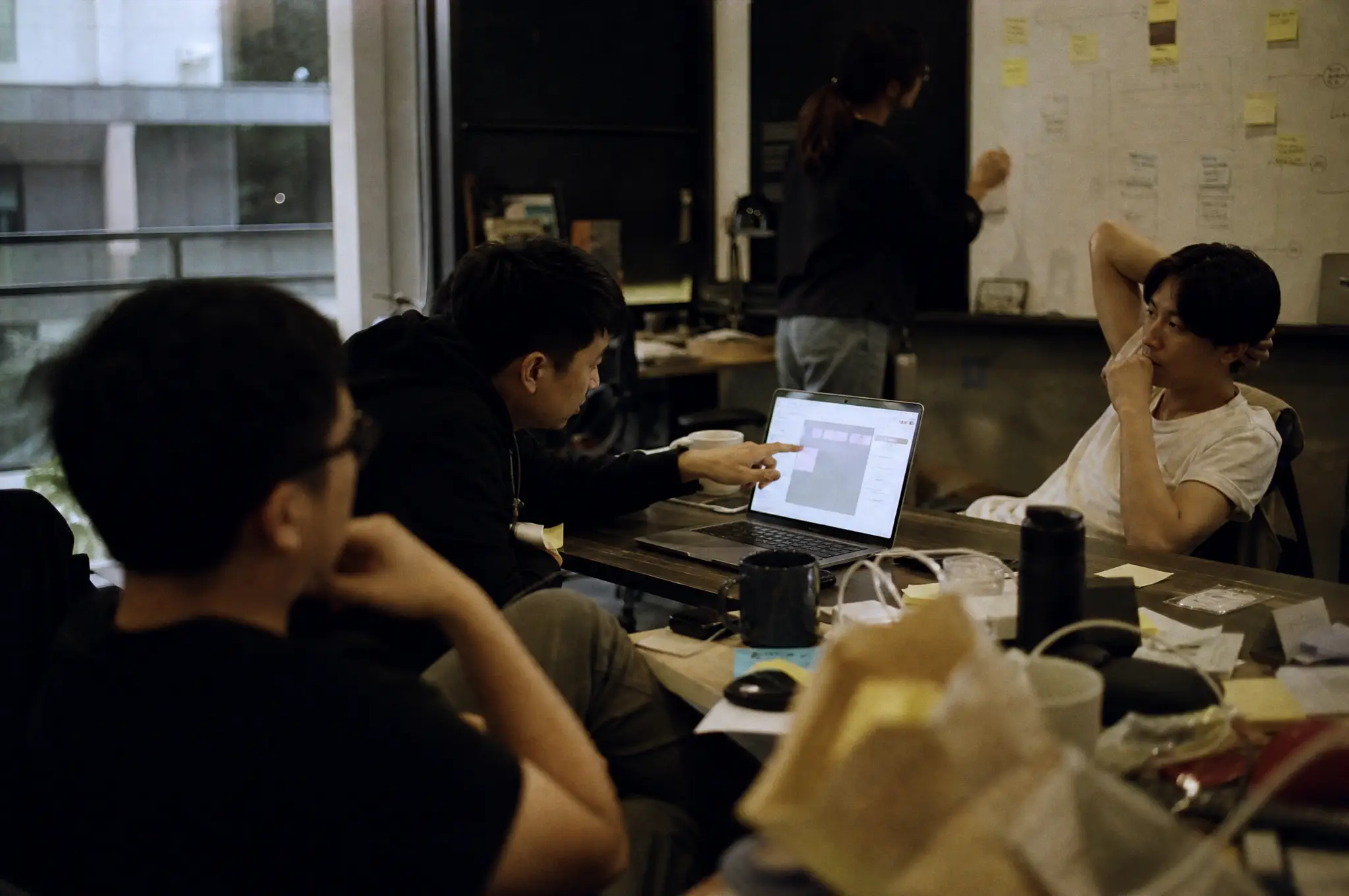 Product team reviewing a low-code workflow around a shared laptop